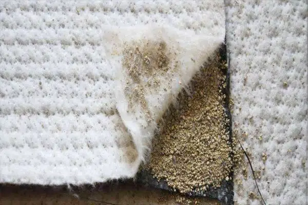 Geosynthetic clay liner material showing a bentonite barrier layer construction