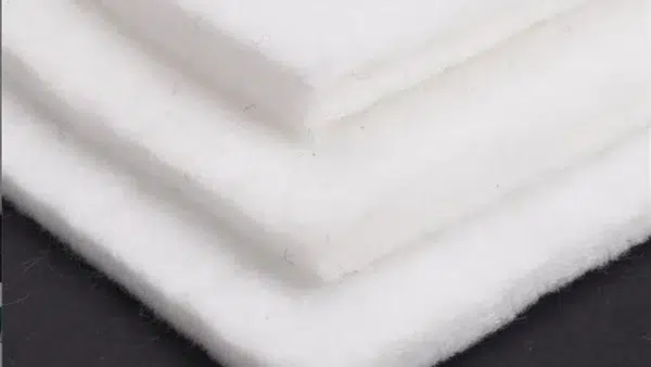 Nonwoven geotextile used as a protection layer beneath an HDPE geomembrane