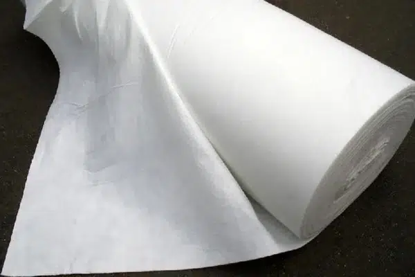Nonwoven geotextile used as cushioning below a geomembrane