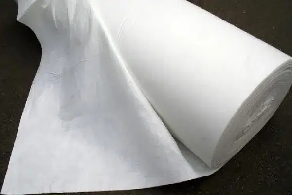 Wide white nonwoven fabric laid out for inspection