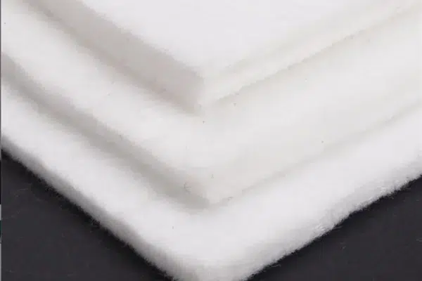 Folded layers of white nonwoven geotextile
